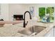 Open kitchen with granite countertops, stainless steel sink, and a view of the living room and fireplace at 4818 Terrace Green Trce, Stone Mountain, GA 30088