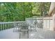 Outdoor deck featuring a table and chairs overlooking the lush, wooded backyard at 6520 Indian Acres Trl, Tucker, GA 30084