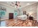 Spacious bedroom features hardwood floors, a ceiling fan, and natural light from multiple windows at 6520 Indian Acres Trl, Tucker, GA 30084