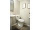 This half bathroom features a pedestal sink, toilet, neutral paint, and updated flooring, creating a clean and functional space at 9130 Charlton Pl, Douglasville, GA 30135