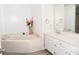 Well-lit bathroom with corner tub and dual sinks at 9130 Charlton Pl, Douglasville, GA 30135