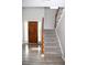 Inviting foyer featuring a wooden front door, staircase and modern flooring for a bright and airy entry at 9130 Charlton Pl, Douglasville, GA 30135