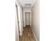 Hallway with wood-look floors and doors leading to storage spaces at 9130 Charlton Pl, Douglasville, GA 30135