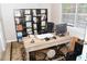 Bright home office featuring a large desk, black bookshelves, a comfortable chair, and natural light at 9130 Charlton Pl, Douglasville, GA 30135