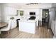 Modern kitchen with an island, stainless steel appliances, and white cabinetry at 9130 Charlton Pl, Douglasville, GA 30135