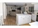 Open-concept living space featuring hardwood floors, a cozy fireplace, and a kitchen island for seamless entertaining at 9130 Charlton Pl, Douglasville, GA 30135