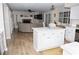 Open-concept living space featuring hardwood floors, a cozy fireplace, and a kitchen island for seamless entertaining at 9130 Charlton Pl, Douglasville, GA 30135