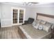 This is a main bedroom with light colored hardwood floors and double french doors to another room at 9130 Charlton Pl, Douglasville, GA 30135