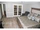 This is a main bedroom with light colored hardwood floors and double french doors to another room at 9130 Charlton Pl, Douglasville, GA 30135