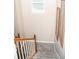 Carpeted staircase featuring wood railings and natural light from a nearby window at 9130 Charlton Pl, Douglasville, GA 30135