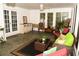 Inviting sunroom featuring whitewashed walls, tile flooring, comfortable seating, and large windows overlooking the outdoors at 9130 Charlton Pl, Douglasville, GA 30135