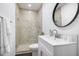 This bathroom features a glass shower and modern vanity with a round mirror at 2358 Armand Ne Rd, Atlanta, GA 30324
