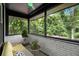Inviting sunroom with large windows offering views of the lush surrounding greenery, and brick accent wall at 2358 Armand Ne Rd, Atlanta, GA 30324