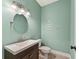 Well-lit bathroom with a dark vanity, sink, toilet, and an oval mirror at 2667 Hampton Park Dr, Marietta, GA 30062
