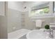 Classic bathroom featuring gray tile, a white tub, and a window with a view to the yard at 2800 Mornington Nw Dr, Atlanta, GA 30327