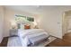 Sunlit bedroom with neutral decor, bench seat, hardwood floors, and view of the outdoors at 2800 Mornington Nw Dr, Atlanta, GA 30327
