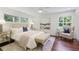 Inviting bedroom featuring hardwood floors, cozy armchair, bench seat, and bright windows at 2800 Mornington Nw Dr, Atlanta, GA 30327