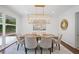 Bright dining room features modern light fixture and views to the wooded backyard at 2800 Mornington Nw Dr, Atlanta, GA 30327