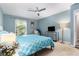 A light blue bedroom with a ceiling fan, a 'Keep Calm and Carry On' sign, and a leafy view from the window at 3251 Abbeywood Dr, Decatur, GA 30034