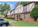 A brick townhouse with Tudor-style accents and a green lawn provides a cozy and inviting atmosphere at 3251 Abbeywood Dr, Decatur, GA 30034