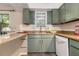 Cozy kitchen features sage-colored cabinetry, stainless steel appliances, and updated countertops at 3251 Abbeywood Dr, Decatur, GA 30034