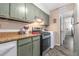 Galley-style kitchen features updated appliances, counters, and sage-colored cabinets at 3251 Abbeywood Dr, Decatur, GA 30034