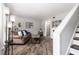 An open living room features hardwood floors, a brown sofa, and a staircase with black painted risers at 3251 Abbeywood Dr, Decatur, GA 30034