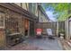 A cozy outdoor patio features seating, potted plants, and a small metal rack on a stone tile surface at 3251 Abbeywood Dr, Decatur, GA 30034