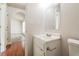 Cozy bathroom with a white single sink vanity, framed mirror, and view to an adjacent room at 4895 Ozment Ridge Ct, Lithonia, GA 30038