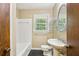 Bathroom featuring white tile, a pedestal sink, a medicine cabinet, and a window for natural light at 763 Brookwood Sw Ter, Lilburn, GA 30047