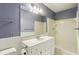 Bathroom with gray-blue walls, a large mirror, white vanity, and a shower/tub combo at 763 Brookwood Sw Ter, Lilburn, GA 30047