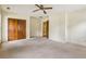 Spacious bedroom featuring neutral carpet, paneled walls, ceiling fan, and a closet with wood doors at 763 Brookwood Sw Ter, Lilburn, GA 30047