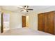 Bedroom with beige walls, neutral carpet, a ceiling fan, and a closet with wood doors at 763 Brookwood Sw Ter, Lilburn, GA 30047