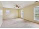 Bright bedroom with neutral carpet, paneled walls, three windows with blinds, and ample natural light at 763 Brookwood Sw Ter, Lilburn, GA 30047