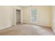 Bedroom featuring neutral carpet, beige walls, a window, and a closet with white bi-fold doors at 763 Brookwood Sw Ter, Lilburn, GA 30047