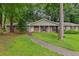 Charming brick home with well-manicured lawn and mature trees, creating a welcoming curb appeal at 763 Brookwood Sw Ter, Lilburn, GA 30047