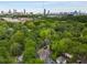 Stunning aerial view of a neighborhood surrounded by lush greenery and a city skyline in the distance at 1020 Austin Ne Ave, Atlanta, GA 30307