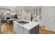 Open kitchen featuring white cabinets, stainless steel appliances, gray island, and adjacent living area at 1020 Austin Ne Ave, Atlanta, GA 30307