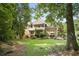 Spacious backyard with lush green grass, mature trees, a stone-lined garden and a cozy outdoor seating area at 4874 Registry Nw Ln, Kennesaw, GA 30152
