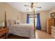 Cozy bedroom with a four-poster bed, a ceiling fan, and natural light from the window at 4874 Registry Nw Ln, Kennesaw, GA 30152