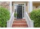Inviting front entrance with brick steps, white railings, and manicured shrubs framing the doorway at 4874 Registry Nw Ln, Kennesaw, GA 30152