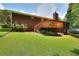 Exterior view of backyard with well-maintained lawn, wooden deck, and mature trees at 1123 Willow Trce, Grayson, GA 30017
