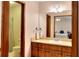 Well-lit bathroom featuring wood cabinets and a sink with vanity, with a bedroom view in the mirror at 1123 Willow Trce, Grayson, GA 30017