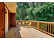A wooden deck with a yellow outdoor table and chairs overlooks a wooded area, providing a serene space at 1123 Willow Trce, Grayson, GA 30017