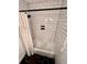 Shower with white subway tile, modern fixtures, and black hexagon floor tiles at 124 Dockside Downs Dr, Woodstock, GA 30189