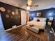 Stylish bedroom featuring dark walls, hardwood floors, updated lighting, and barn door to the walk-in closet at 124 Dockside Downs Dr, Woodstock, GA 30189