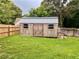 Storage shed with wood doors and a metal roof in the spacious, green backyard at 124 Dockside Downs Dr, Woodstock, GA 30189