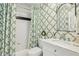 Bathroom featuring patterned wallpaper, tiled shower with patterned curtain, and stylish fixtures at 1600 Belle Isle Ne Cir, Atlanta, GA 30329