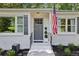 Close-up of the white brick home's entrance, highlighting the gray door, shutters and manicured landscaping at 1600 Belle Isle Ne Cir, Atlanta, GA 30329