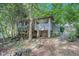 Rear exterior of raised home with wooden stairs, surrounded by natural greenery and trees at 239 Haas Se Ave, Atlanta, GA 30316